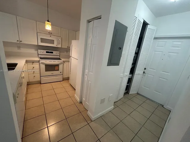 a kitchen with white cabinets and white appliances