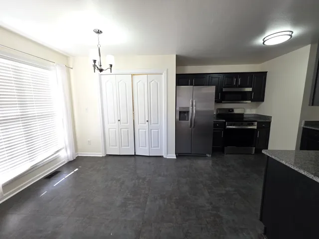 a view of a kitchen with refrigerator and a stove