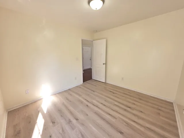 a view of an empty room and wooden floor