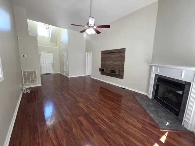 a view of a livingroom with wooden floor and a fireplace