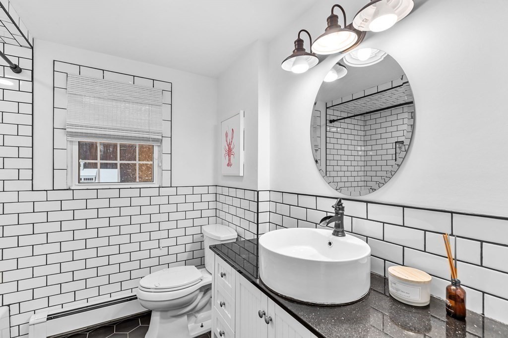 207 Tilden Road Scituate, MA 02066 - Photo 19 of 42 a bathroom with a sink a toilet and mirror