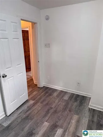 an empty room with wooden floor and closet