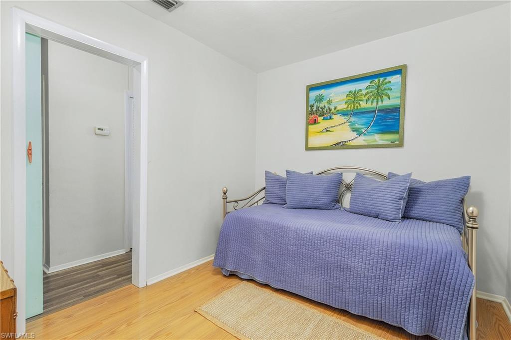 1281 10th Street North Naples, FL 34102 - Photo 15 of 31 Bedroom featuring wood finished floors and baseboards