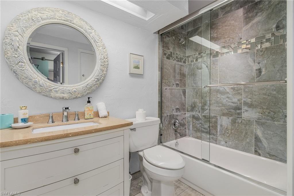 1281 10th Street North Naples, FL 34102 - Photo 17 of 31 Bathroom with vanity and shower / bath combination with glass door