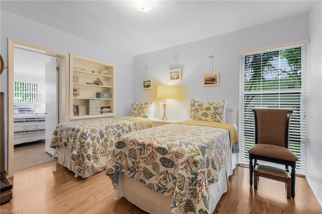 1281 10th Street North Naples, FL 34102 - Photo 21 of 31 Bedroom with wood finished floors and multiple windows