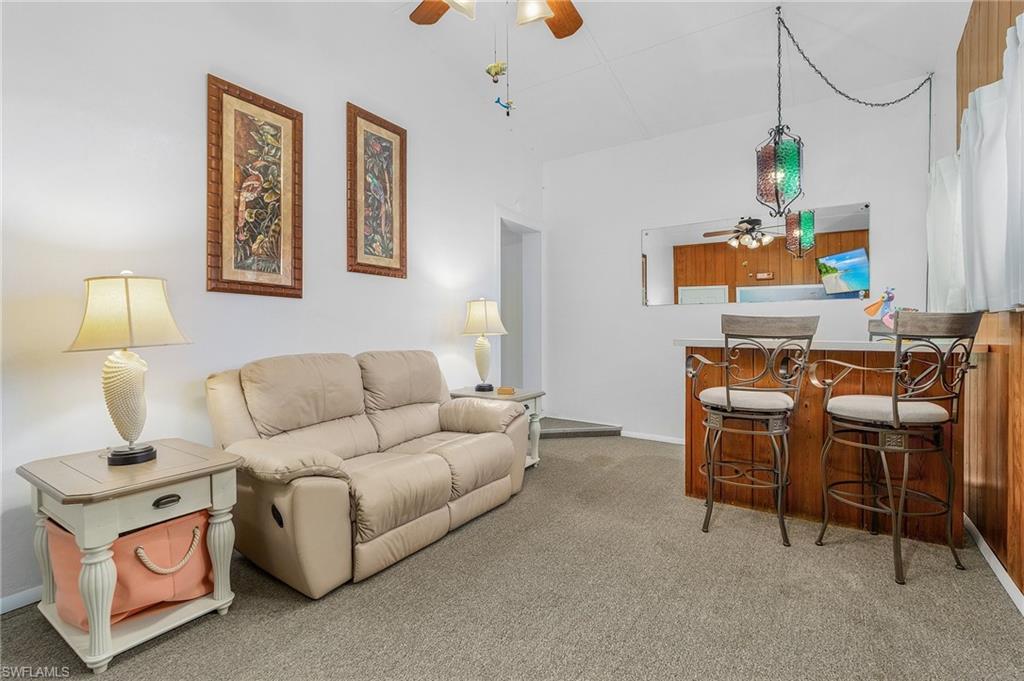 1281 10th Street North Naples, FL 34102 - Photo 23 of 31 Carpeted living area featuring a ceiling fan and baseboards