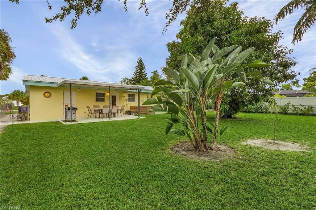 1281 10th Street North Naples, FL 34102 - Photo 8 of 31 Rear view of property with stucco siding, a patio area, and a metal roof