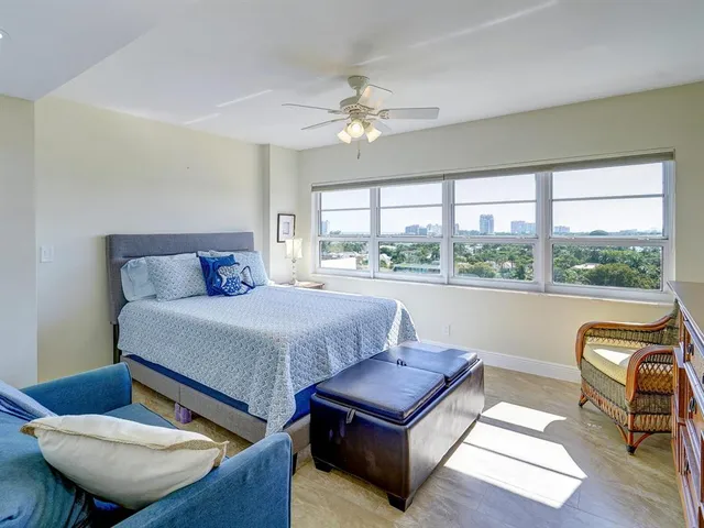 a bedroom with furniture and a large window