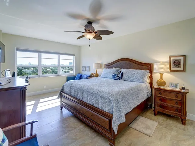a bedroom with a large bed and a chandelier fan