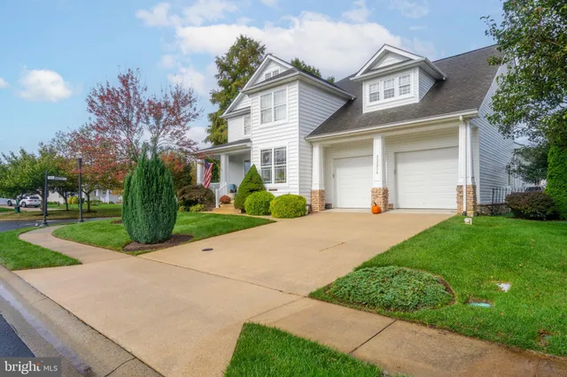 a front view of a house with a yard and potted plants