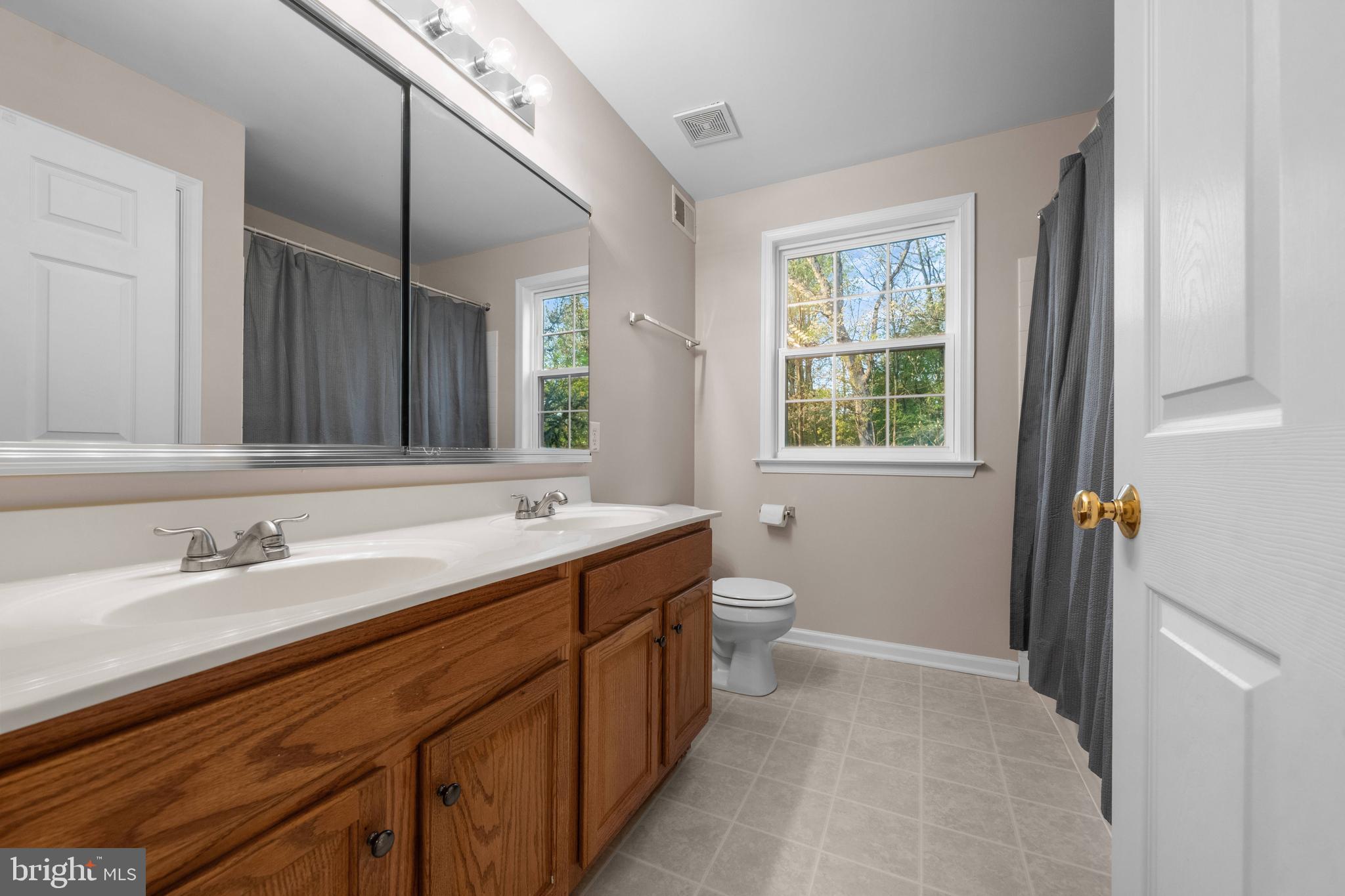 419 Townsend Drive Perkasie, PA 18944 - Photo 26 of 37 a bathroom with a double vanity sink toilet and a mirror