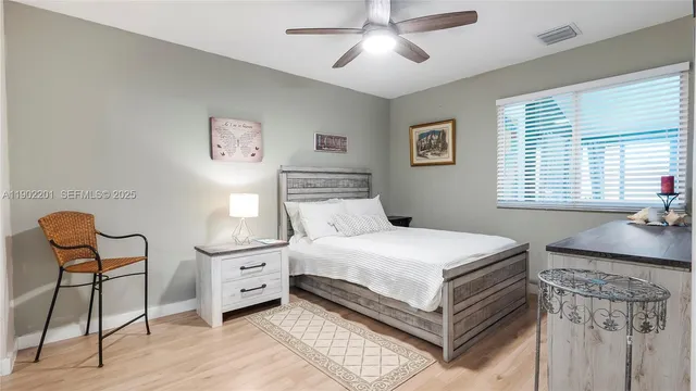 a bedroom with a bed and a chair with the wooden floor