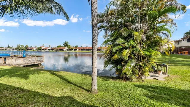 a view of a lake with a big yard and large trees
