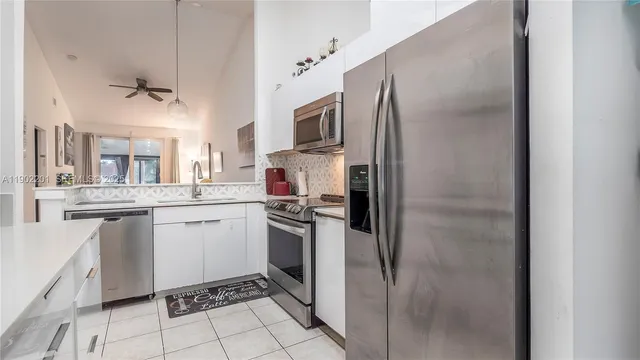 a kitchen with stainless steel appliances a refrigerator sink and microwave