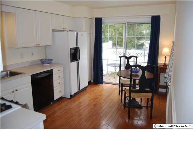 2 Painted Wagon Road Holmdel, NJ 07733 - Photo 2 of 3 a kitchen with stainless steel appliances kitchen island hardwood floor sink stove dining table and chairs