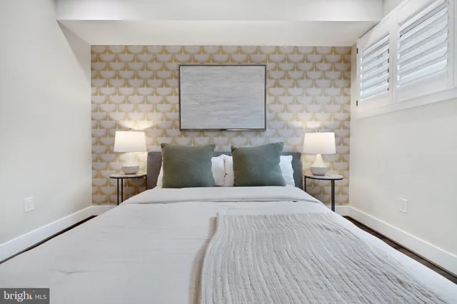 a large bed sitting in a bedroom next to a window