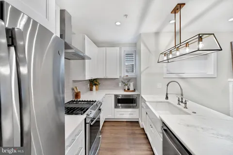 a large white kitchen with a sink and white cabinets