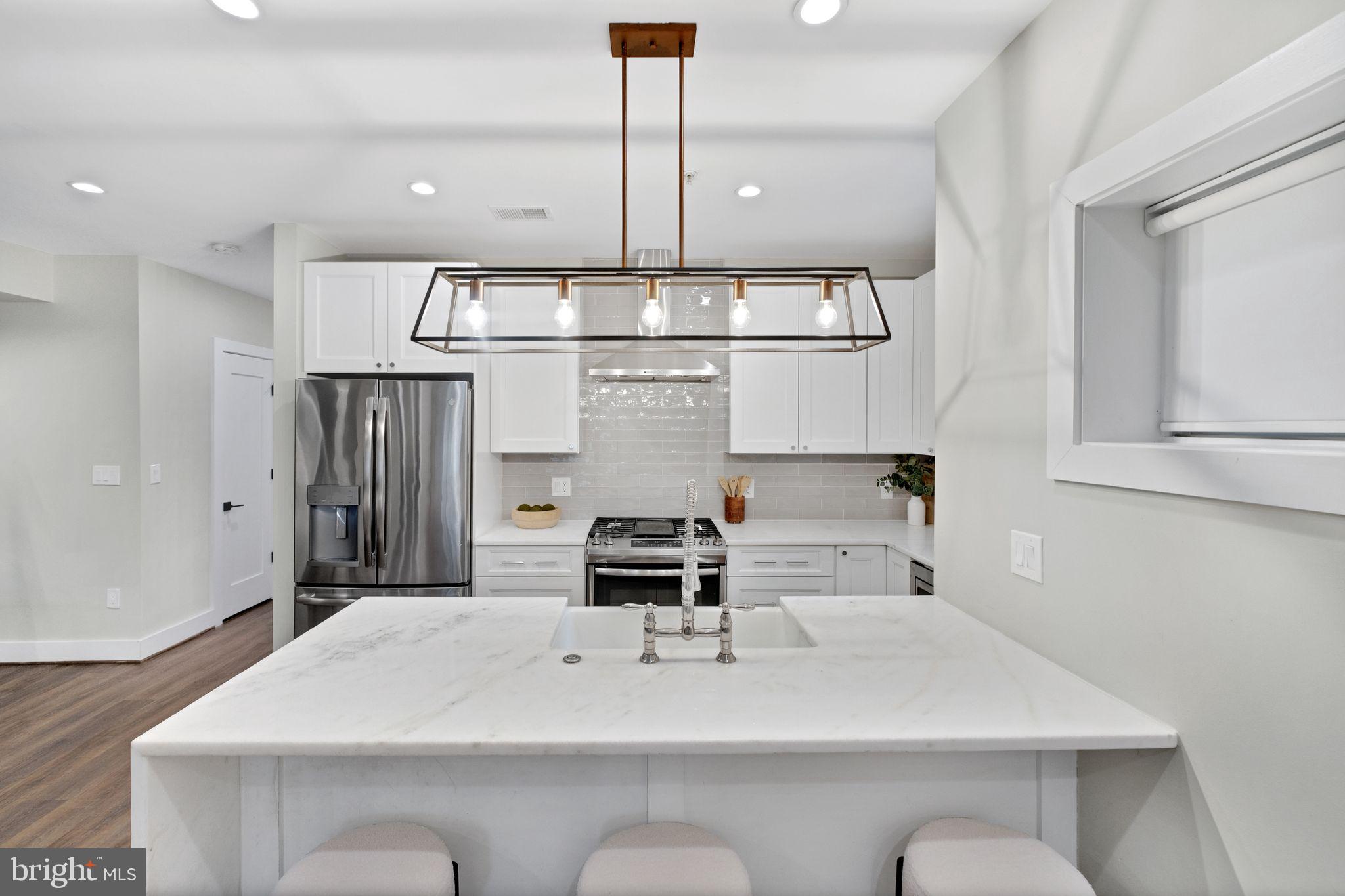 1419 Upshur Street Northwest, Unit 1 Washington, DC 20011 - Photo 7 of 28 a large white kitchen with a sink and white cabinets
