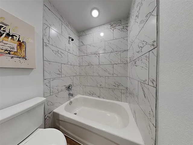 a white bath tub sitting next to a white toilet