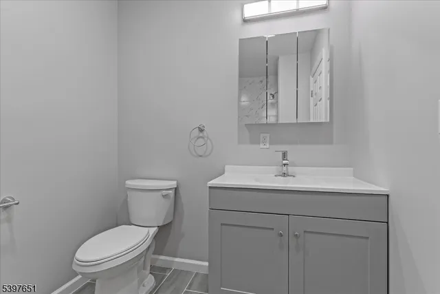 a bathroom with a toilet a sink and mirror