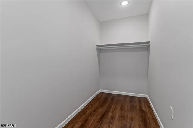 a view of a small space with wooden floor and a window