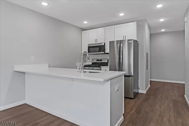 a kitchen with stainless steel appliances a refrigerator and a stove top oven