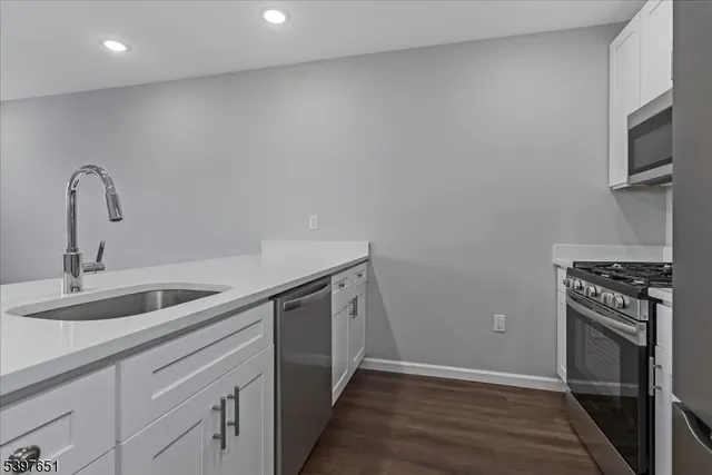 a kitchen with a sink and stainless steel appliances