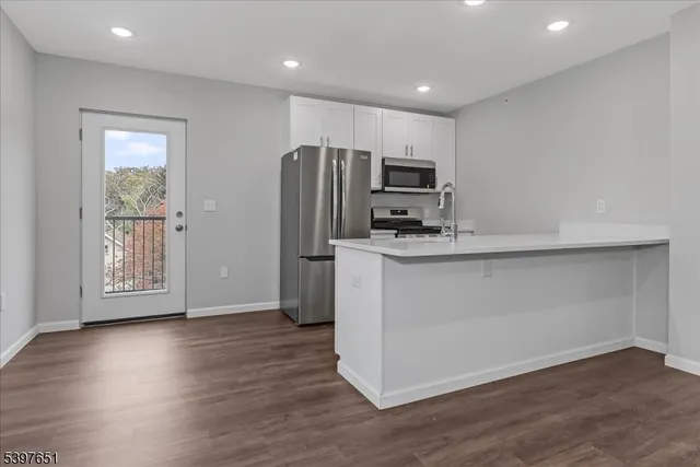 a kitchen with stainless steel appliances a microwave a sink and a refrigerator