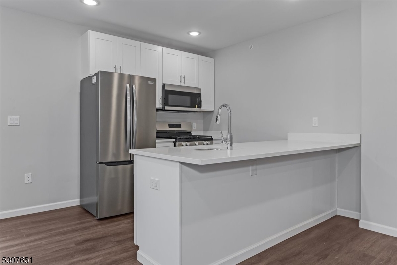 224 Broad Street Bloomfield, NJ 07003 - Photo 8 of 45 a kitchen with kitchen island a sink stainless steel appliances and wooden floor
