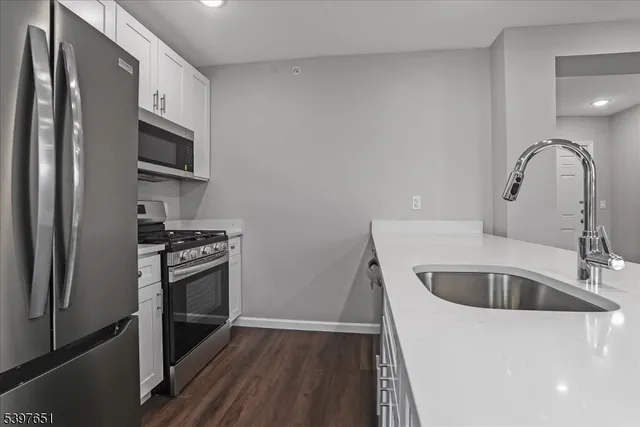 a kitchen with a sink cabinets and stainless steel appliances