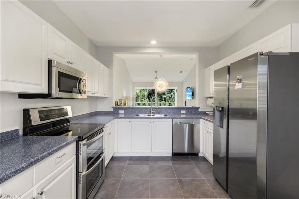 650 Luisa Lane, Unit 4 Naples, FL 34104 - Photo 8 of 19 a kitchen with a sink stainless steel appliances and cabinets