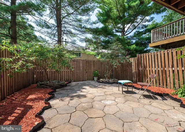 a view of backyard with wooden fence and a large tree