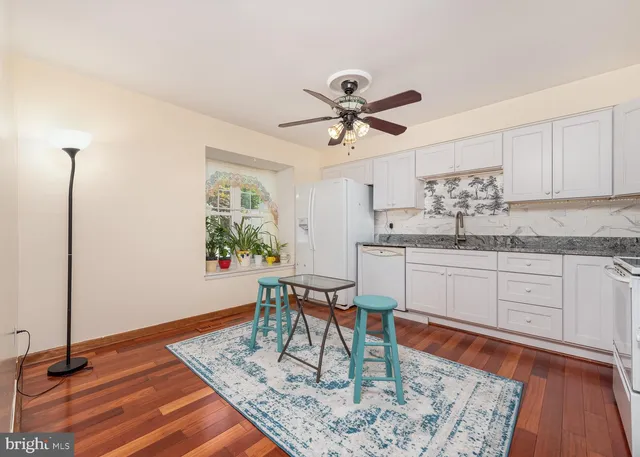 a kitchen with granite countertop sink cabinets and wooden floor