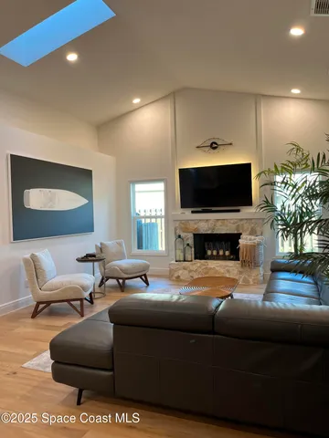 a living room with furniture a potted plant and a fireplace