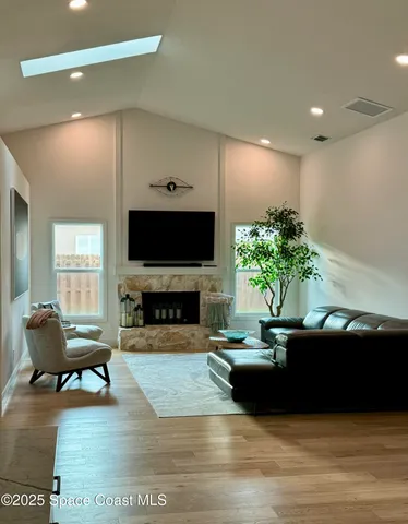 a living room with furniture a fireplace and a flat screen tv