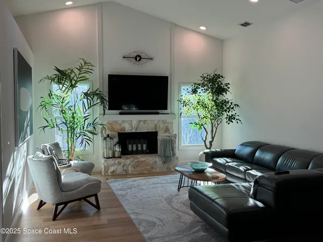 a living room with furniture a dining table and a flat screen tv with kitchen view