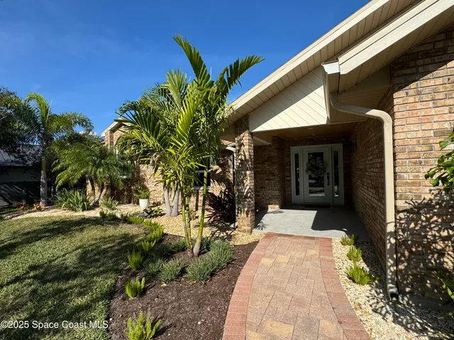 a living room with furniture a kitchen view and a wooden floor