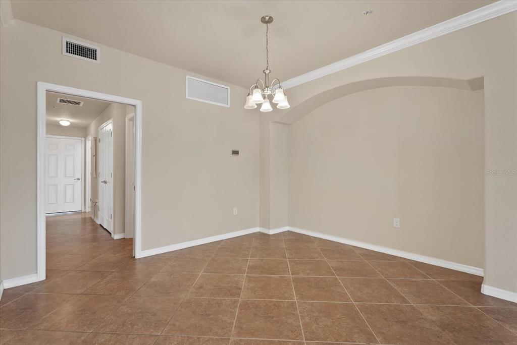 20080 Ragazza Circle, Unit 102 Venice, FL 34293 - Photo 18 of 49 a view of an empty room with a chandelier fan