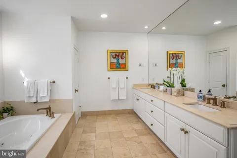 a spacious bathroom with a tub sink and mirror