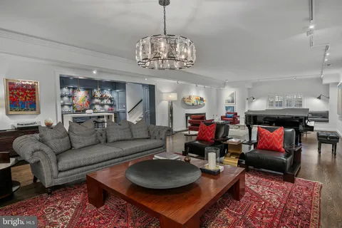 a living room with furniture a dining table and a chandelier