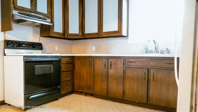 a view of kitchen with granite countertop cabinets and refrigerator