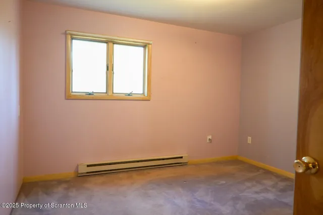 a view of a room with wooden floor and window