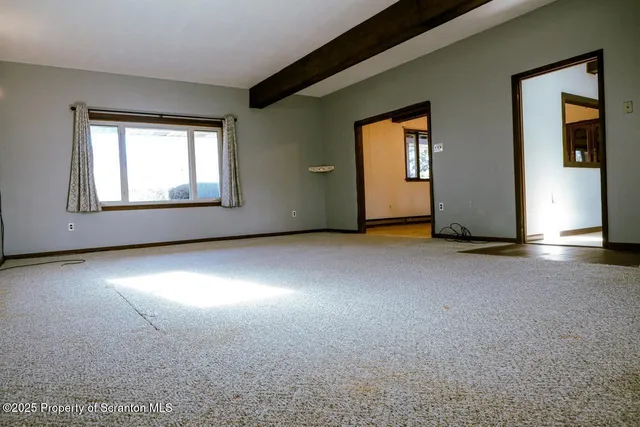 a view of a livingroom with an empty space and a window