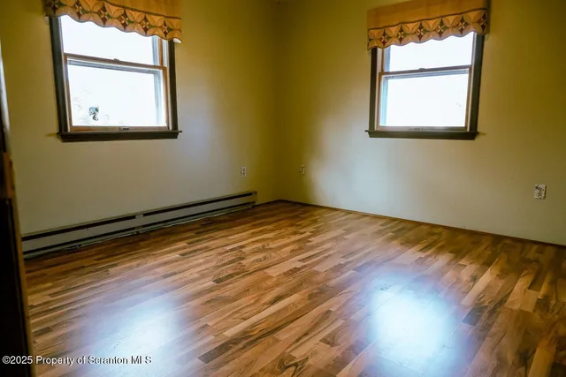 a view of a room with wooden floor and windows