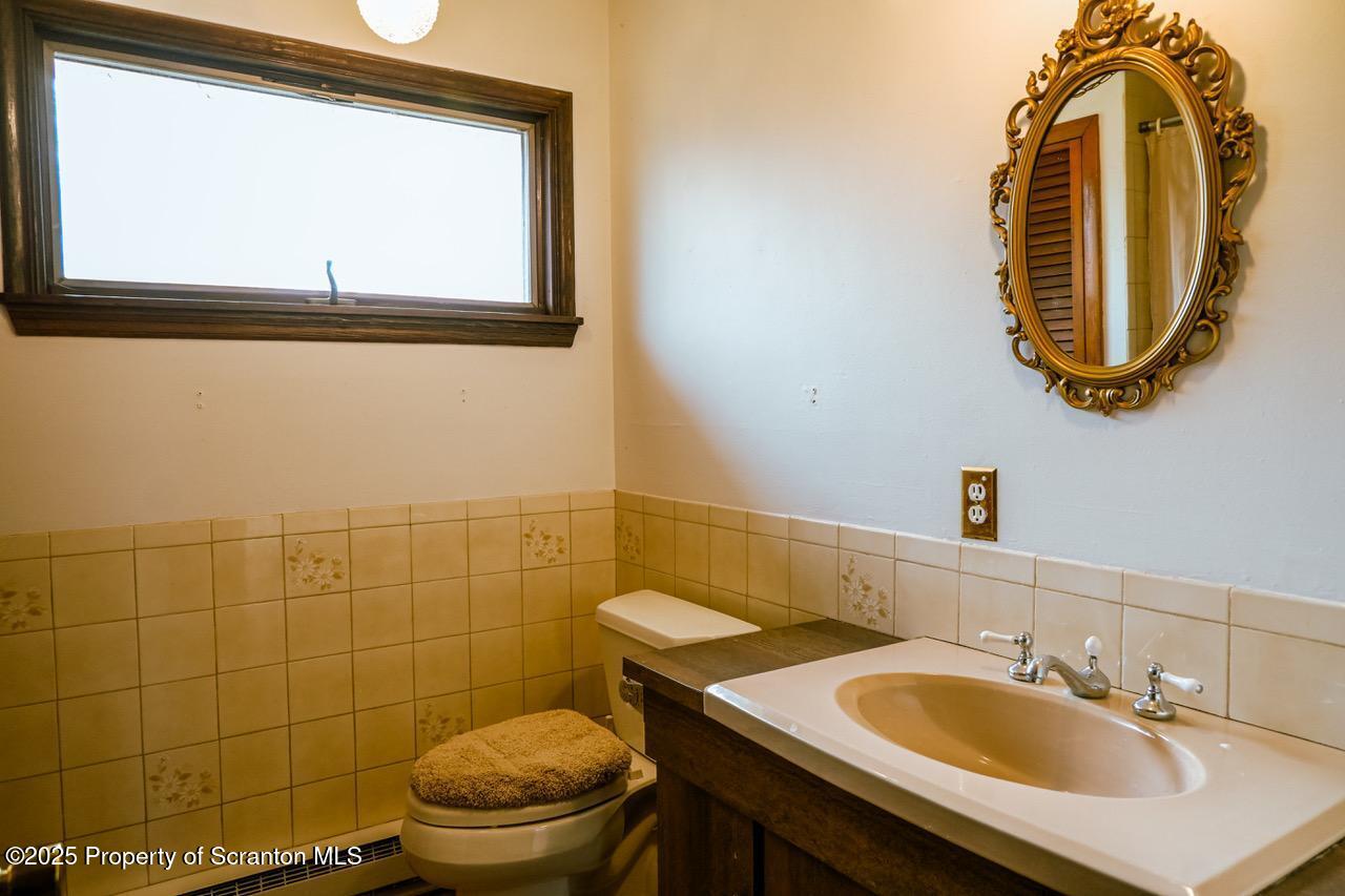 211 Wimmers Road Lake Ariel, PA 18436 - Photo 59 of 65 a bathroom with a sink a toilet and a mirror
