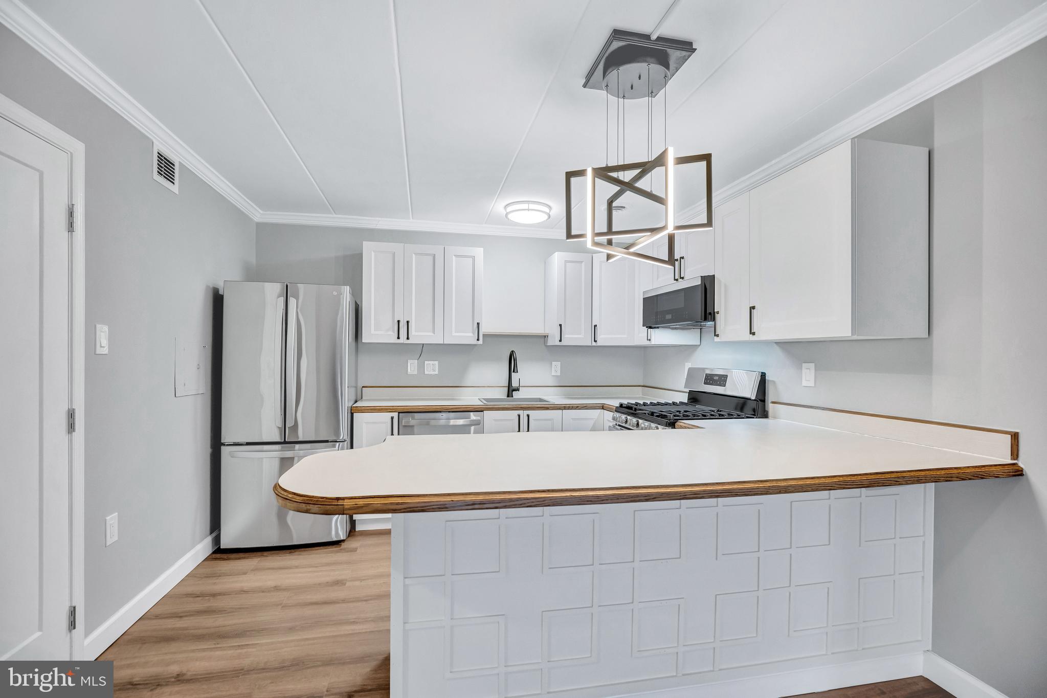 2605 Fort Farnsworth Road, Unit 314 Alexandria, VA 22303 - Photo 11 of 34 a kitchen with stainless steel appliances white cabinets a sink a stove a refrigerator and island
