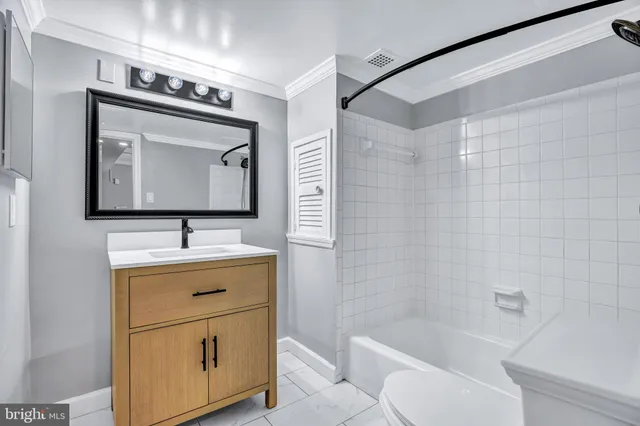 a bathroom with a toilet sink vanity tub and mirror