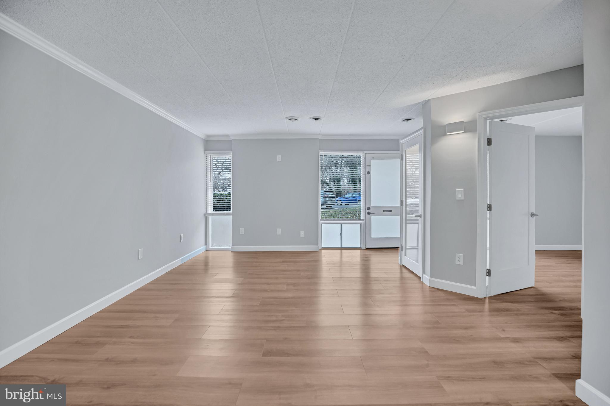 2605 Fort Farnsworth Road, Unit 314 Alexandria, VA 22303 - Photo 2 of 34 a view of an empty room with wooden floor and a window