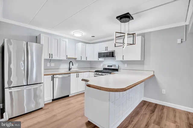 a kitchen with kitchen island a white cabinets and refrigerator