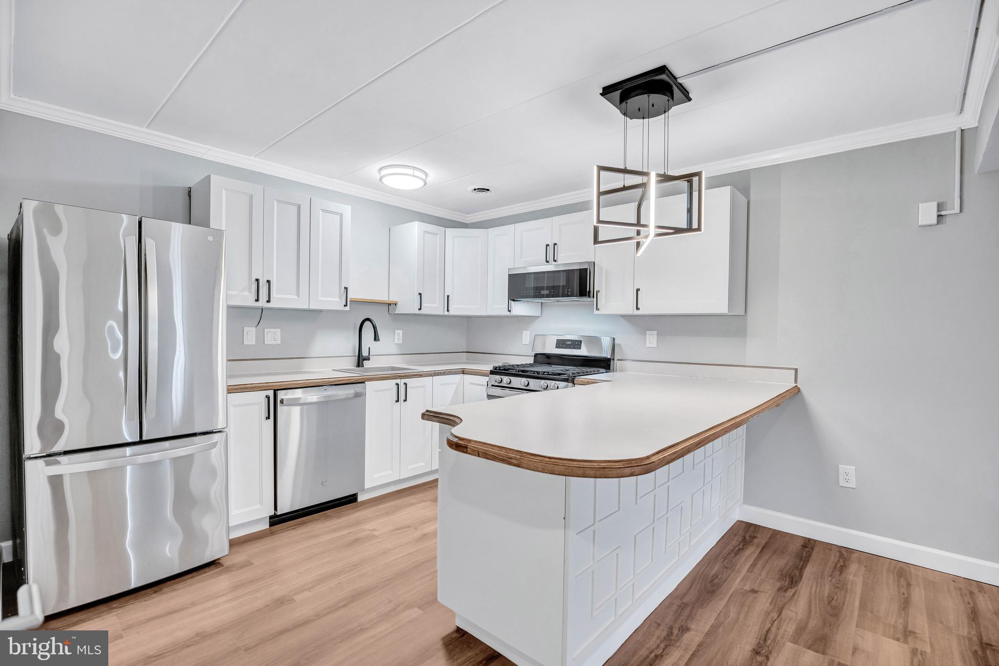 2605 Fort Farnsworth Road, Unit 314 Alexandria, VA 22303 - Photo 10 of 34 a kitchen with kitchen island a white cabinets and refrigerator